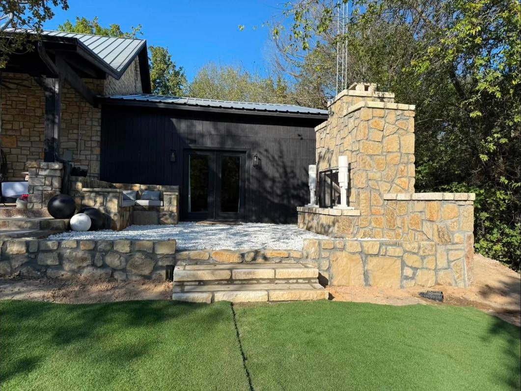 Stone chimney and terrace wall with cut stone steps down to turf