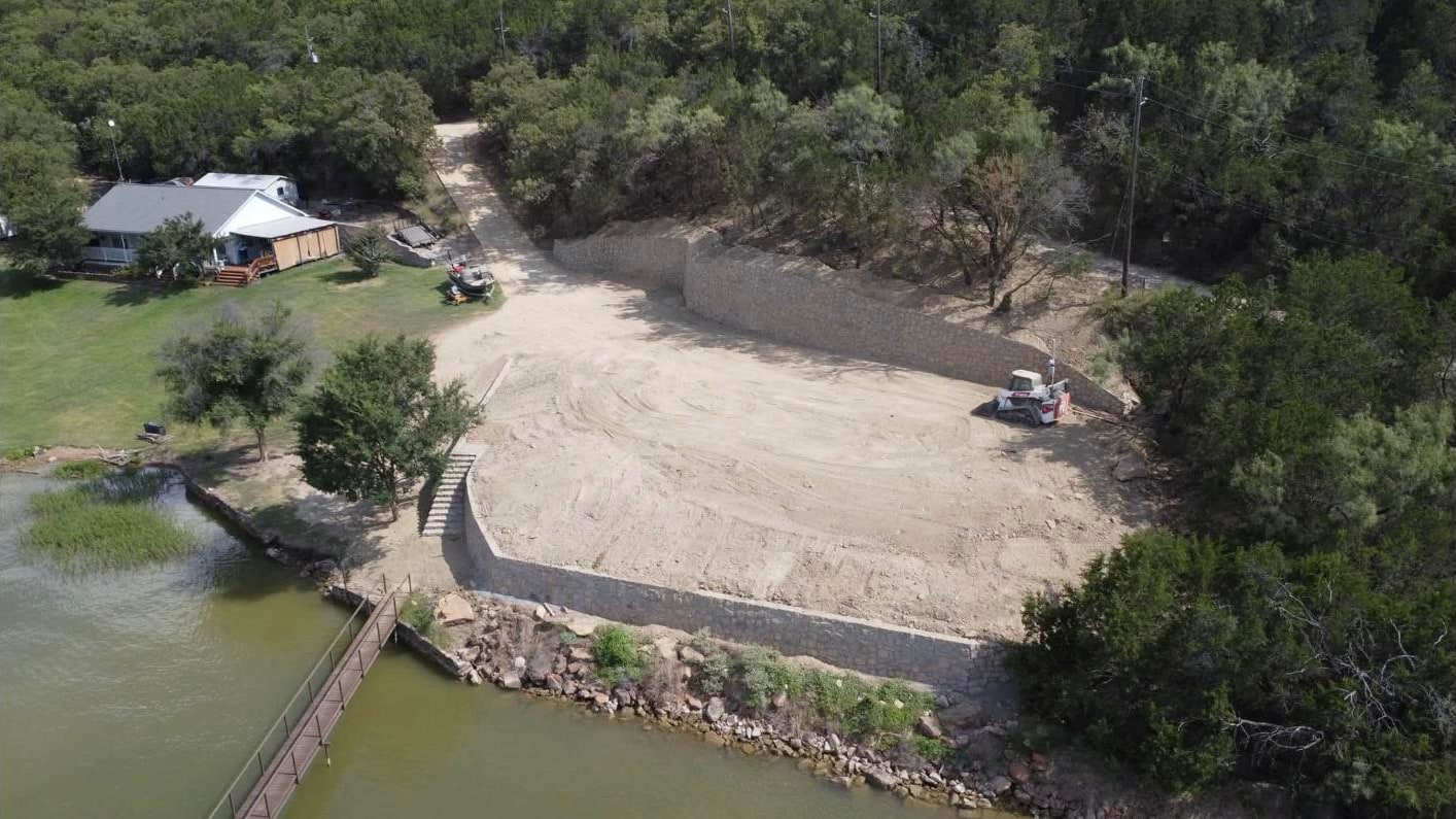 Aerial of the finished retaining wall system and building pad above the water